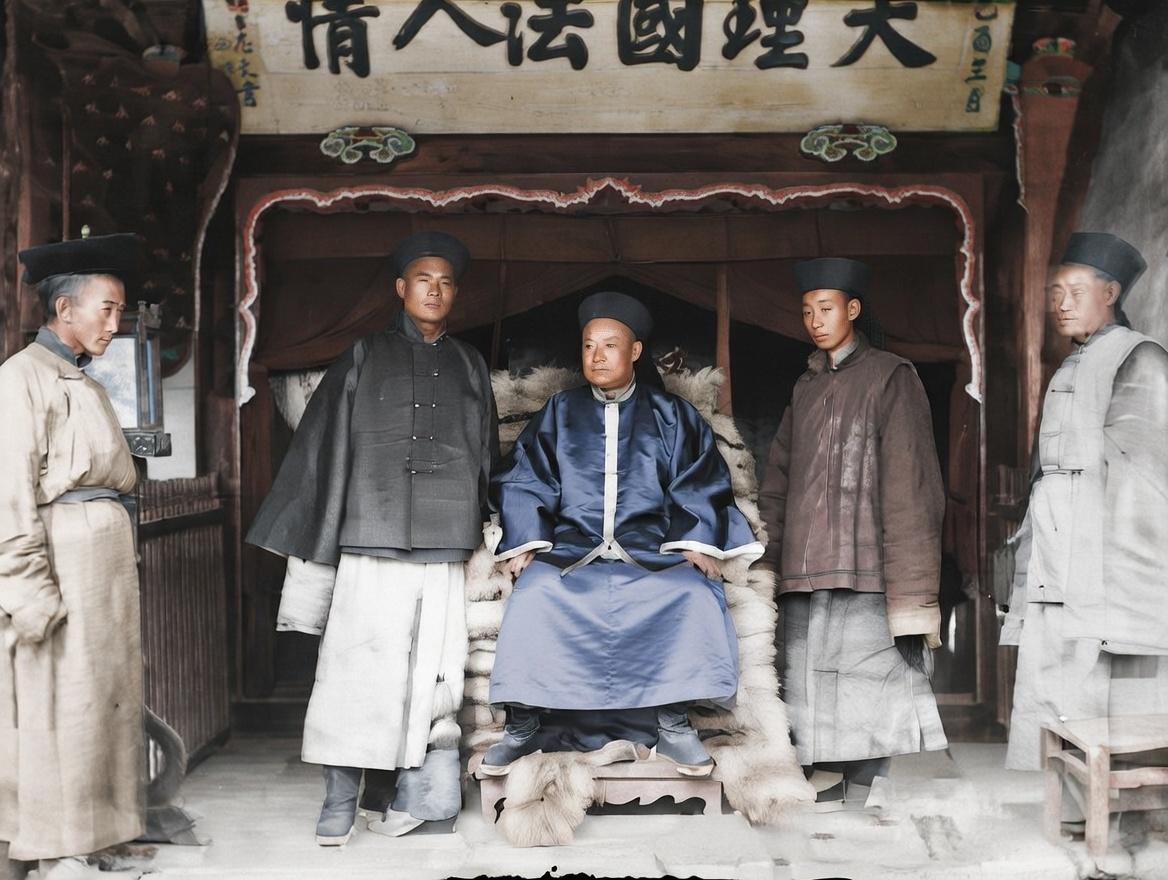 晚清，一处官署中，照片中间端坐的是一位地方官员，他身着官服，头戴暖帽，正襟危坐，