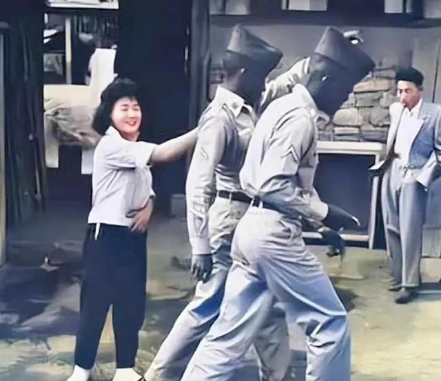 1952年，一名南朝鲜女子给两名美军做完服务后，当着老公的面热情地送大兵们离开。