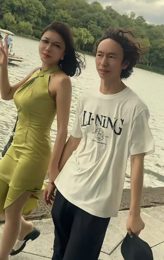 庞麦郎跟龚玥菲漫步在杭州湖边，龚玥菲抓着庞麦郎的手腕，庞麦郎有些害羞，不敢看龚玥