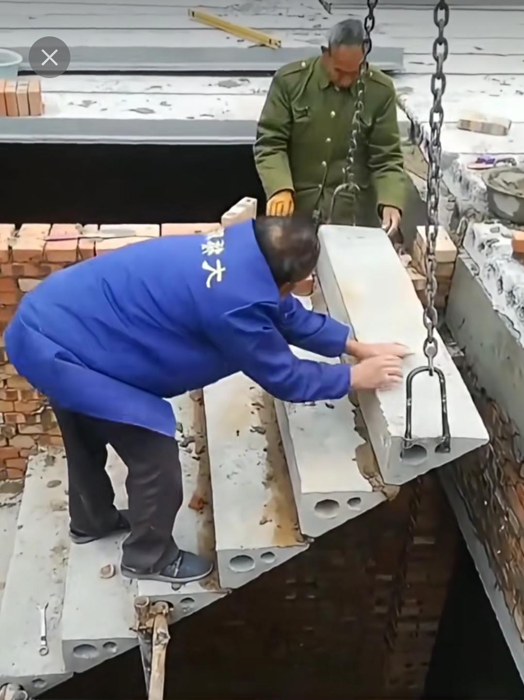 建房子时用预制板搭建楼梯，还有人站在上面协助定位。这般建造楼梯，越往上越危险，看