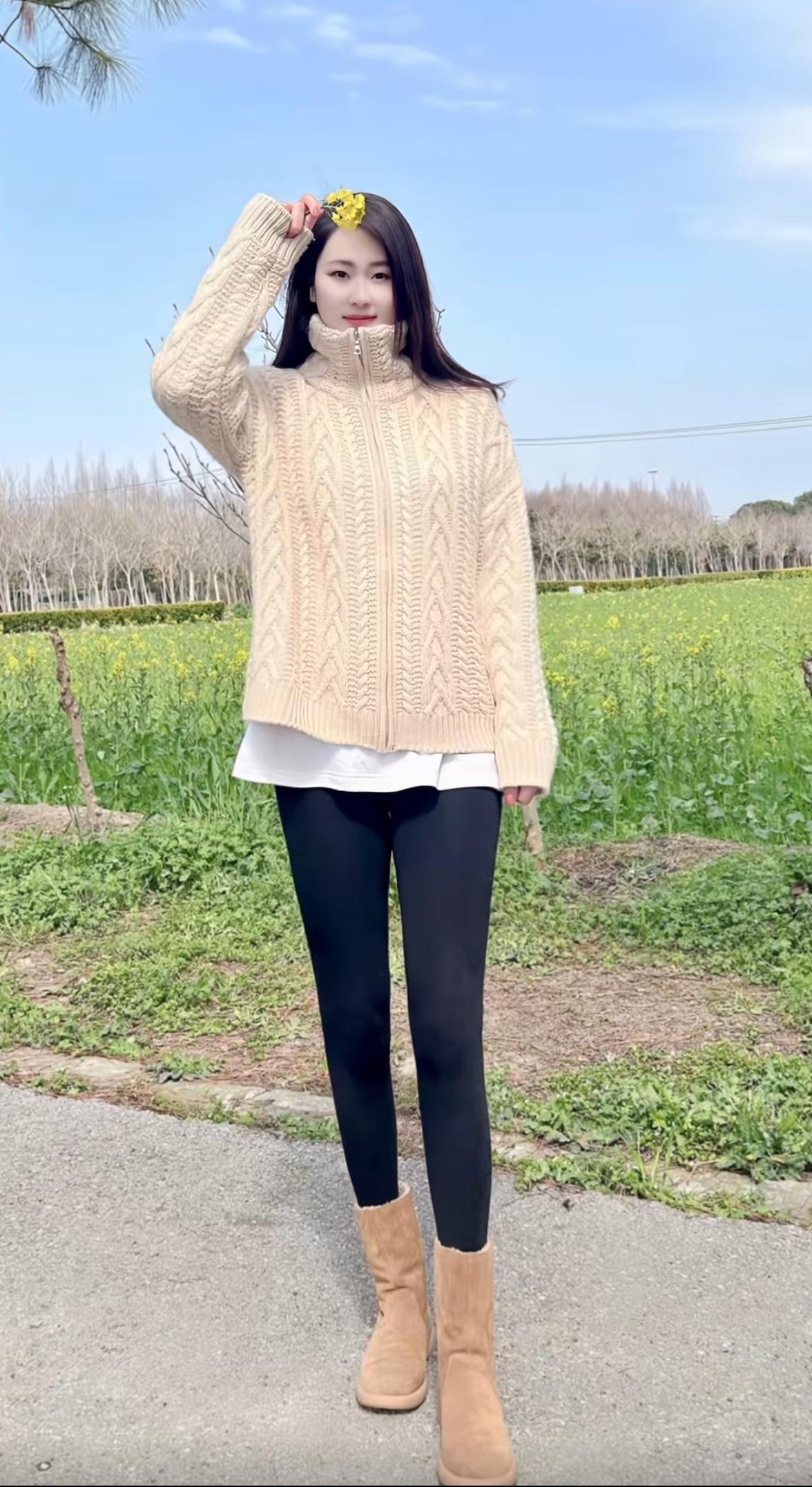 穿得暖和，站在花田里拍照。