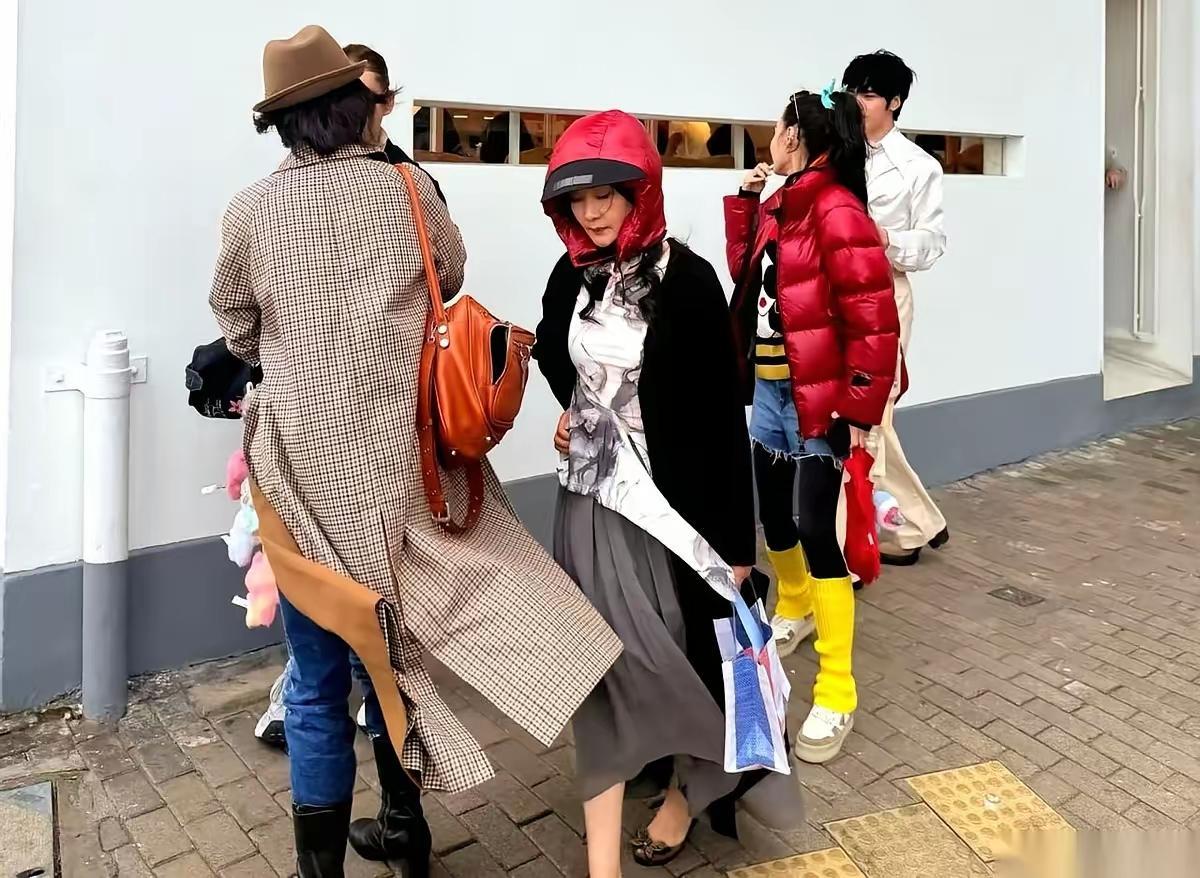 在港岛街头逛吃遇到下雨，张柏芝把帽子拆下来给何赛飞老奶戴上，这波尊老做🉐很到位