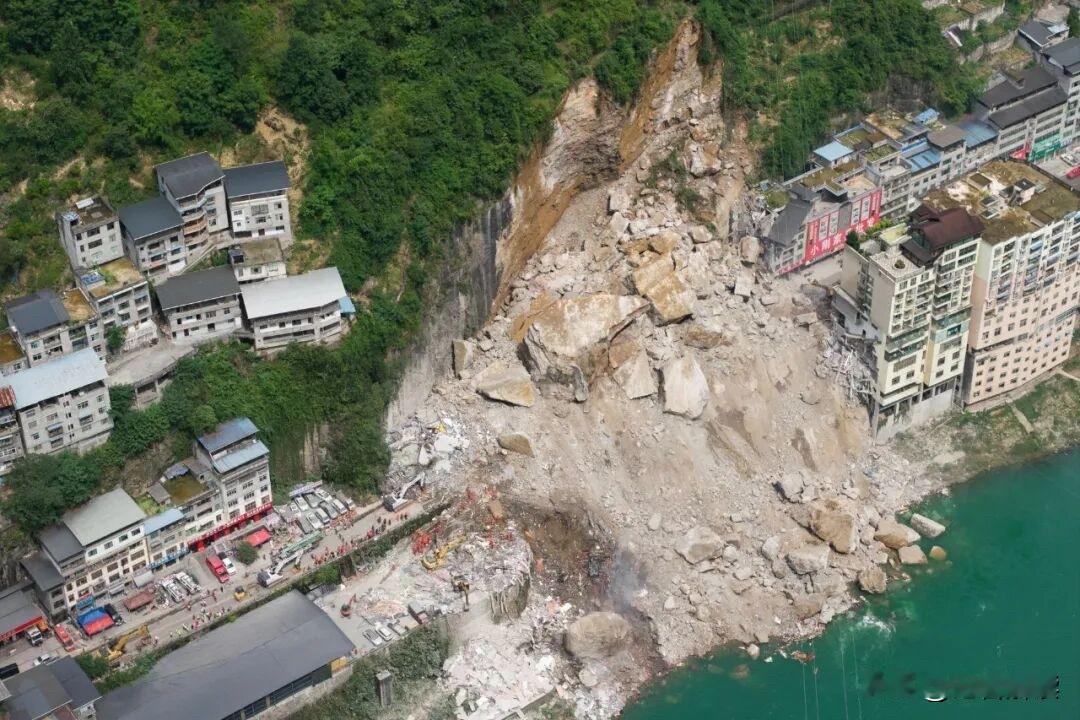 航拍镜头下，重庆彭水江畔山体轰然崩塌，巨石掩埋民居，平静江面旁满目狼藉。一场
