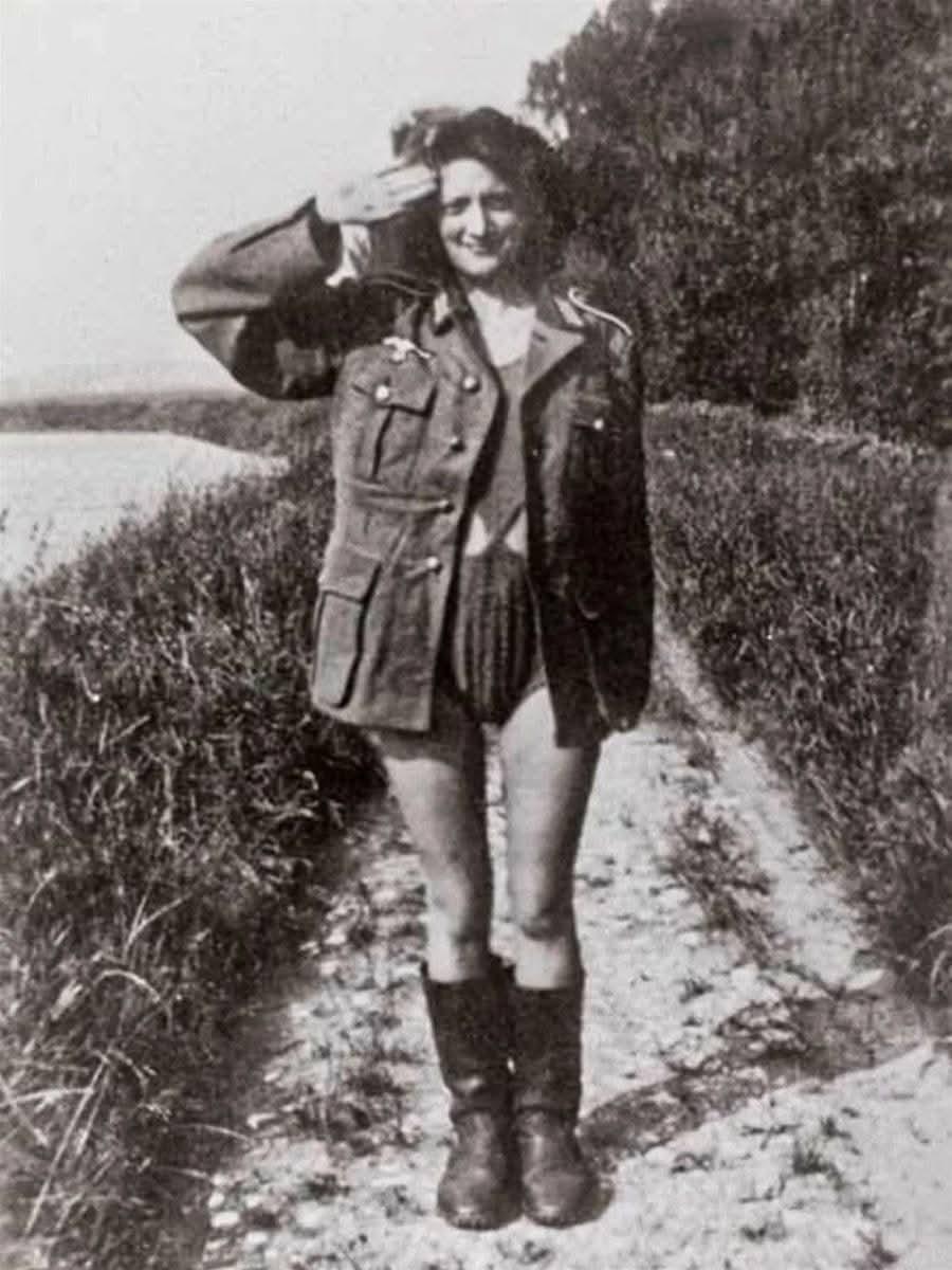 这是一张从德军战俘私人收藏中搜出的照片，一名法国女性正身着男友的野战服，对着镜头
