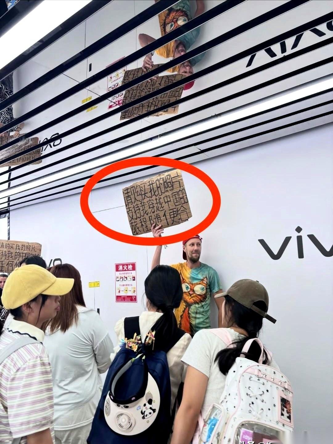 6月17日，长沙街头一个老外举着硬纸板，站在人流最密的地方，牌子上写着：“请购买