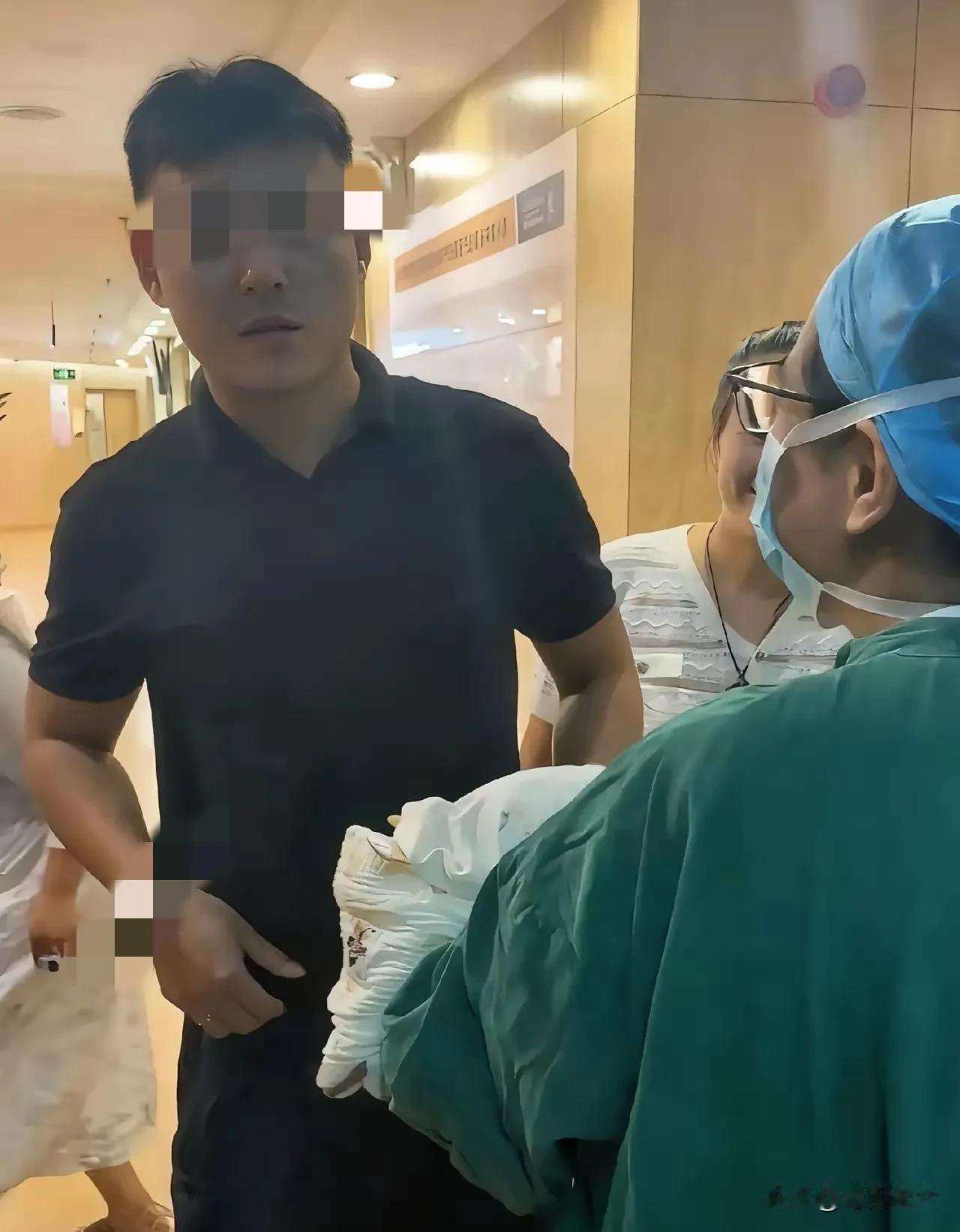 护士抱着刚出生的宝宝从产房里出来，见到孩子爸爸后，护士让他猜猜是男孩还是女孩，爸