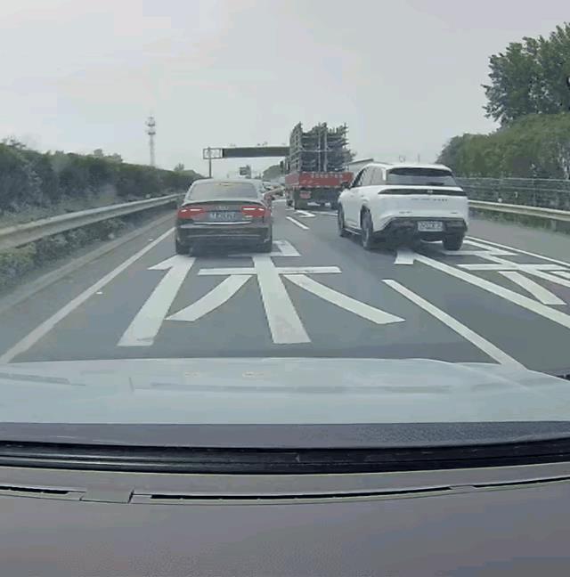 这是前几天发生在安徽某条高速上的一幕，一辆挂着四川牌照的黑色奥迪车占着超车道慢速