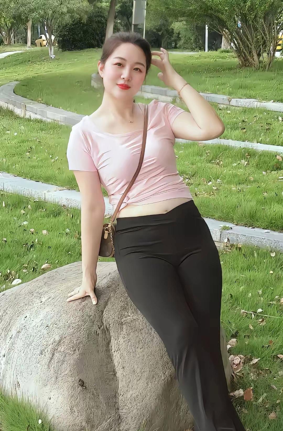 姐姐这身粉黑搭配在公园里太出挑啦！粉色短袖勾勒出柔美曲线，黑色长裤衬得身姿挺拔，