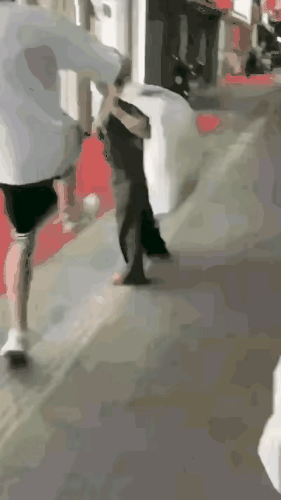 一位拾荒的老人走在大街上，两个小子抬脚就踹，你踹一脚，我踹一脚，直到把老人踹躺在