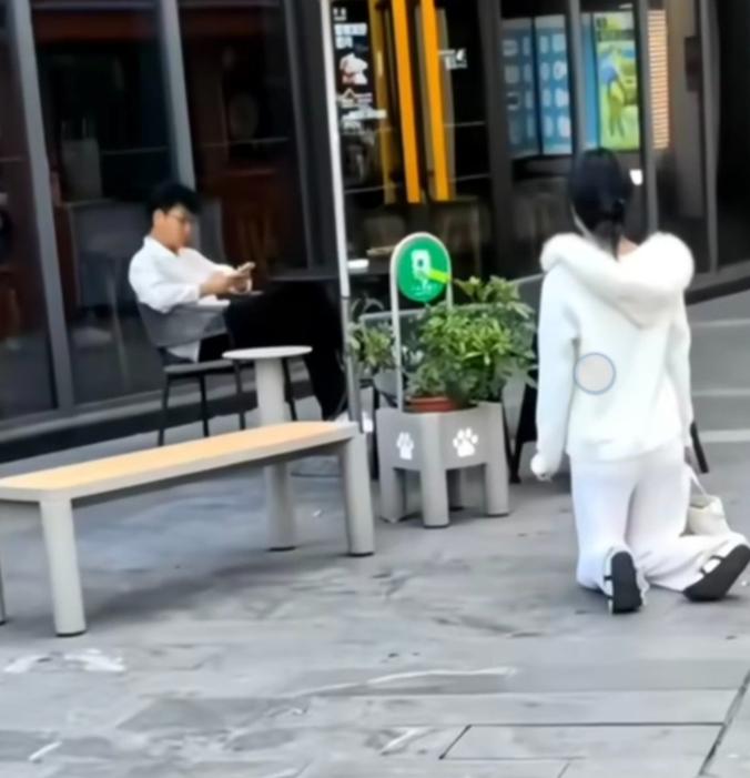 5月16日上海广场，拍下最冷漠的一幕。一名女子当众对着男子双膝下跪，可男子