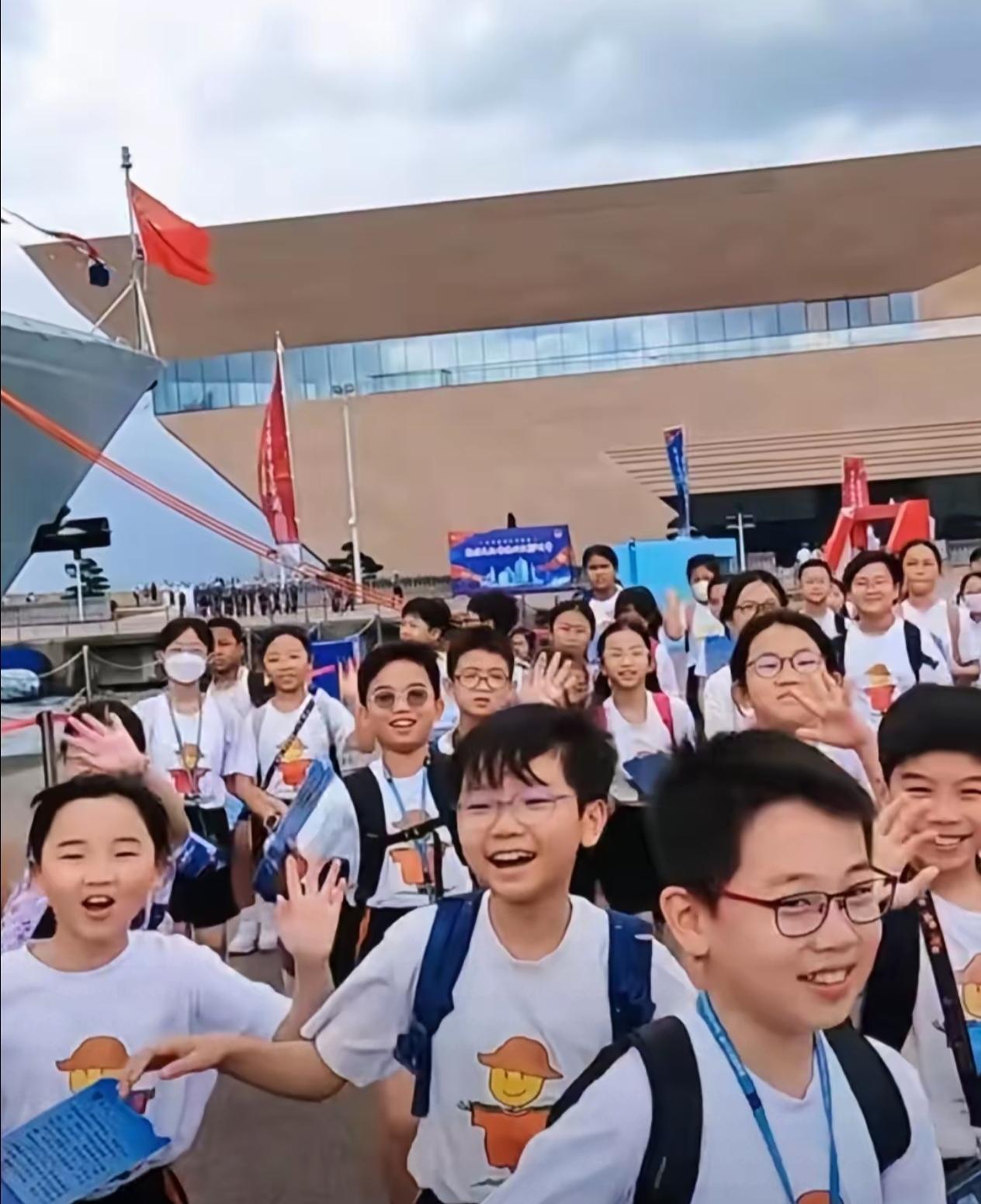 一群笑容满面的香港少年，兴高采烈地参观海军访港的军舰。这帮孩子看上去非常阳光，他