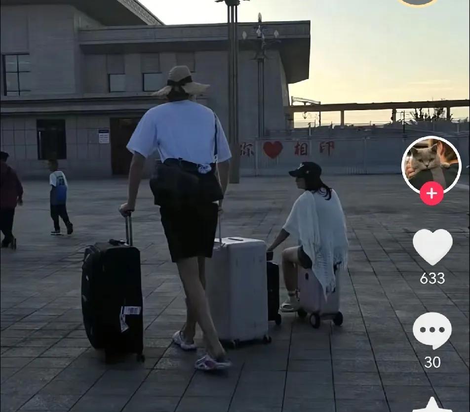 杨瀚森和女友在新疆旅游被偶遇非常甜蜜，杨瀚森推着两个大行李箱女友坐在小行李箱上，