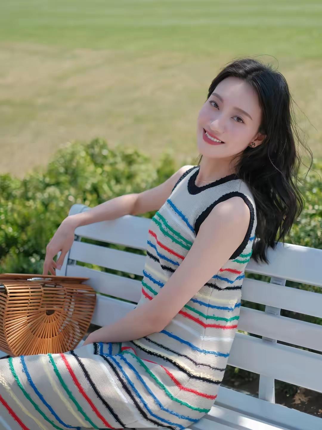 阳光明媚，她在长椅上微笑。