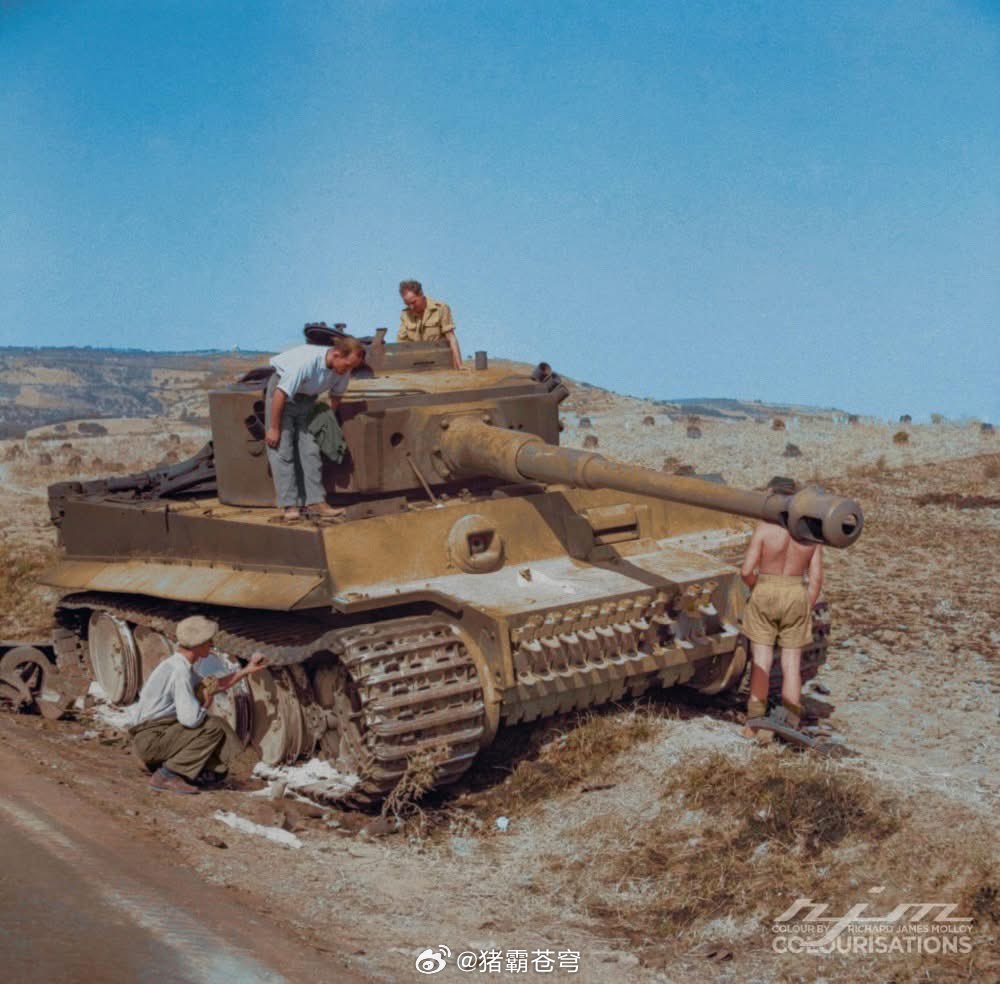 二战1943年7月19日，英国士兵和西西里岛平民正在查看一辆被击毁的德国六号虎