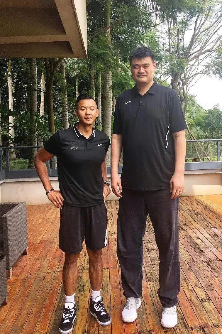 黑人陈建州站在巨人姚明身边，有种小鸟依人的感觉。