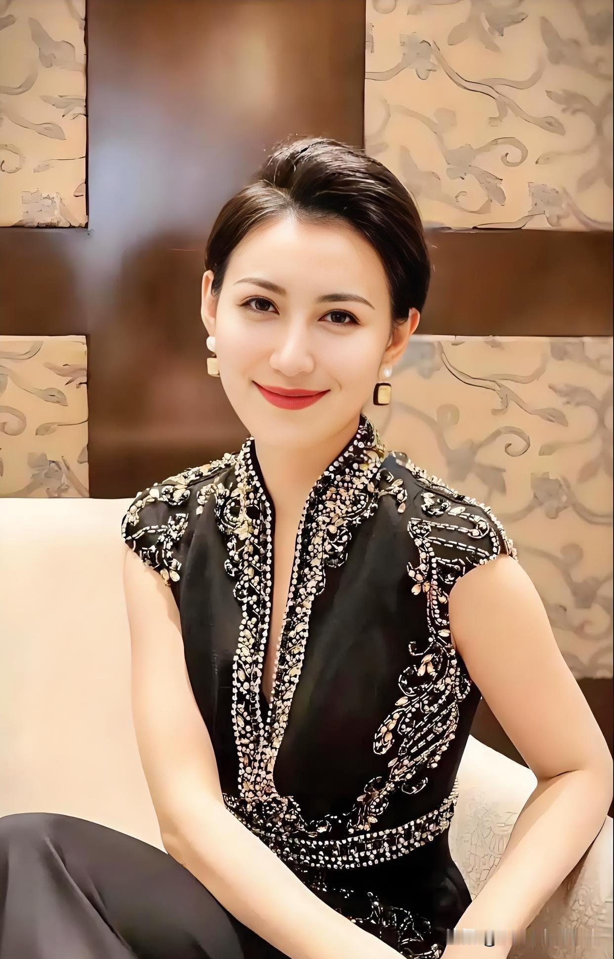 黑金刺绣礼服，勾勒曼妙曲线。盘发精致，红唇微扬，端庄之中透着古典与现代交融的华贵