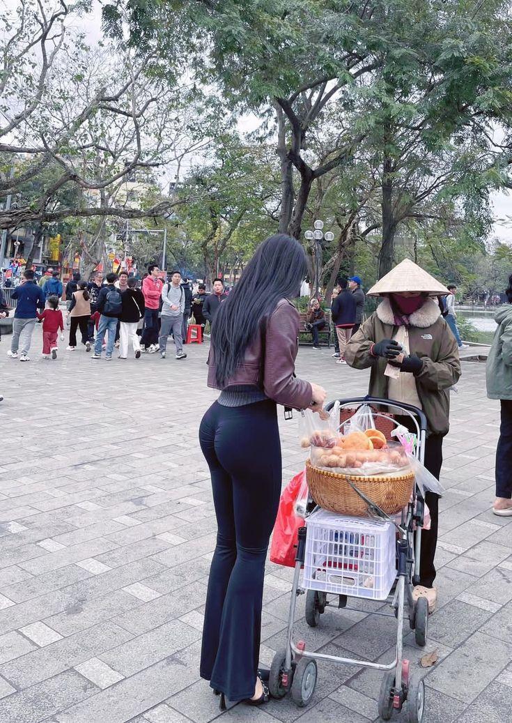 从背后看去，她就像一幅突然闯入视线的行走的画。乌黑长发如丝绸般垂落至腰，风一吹