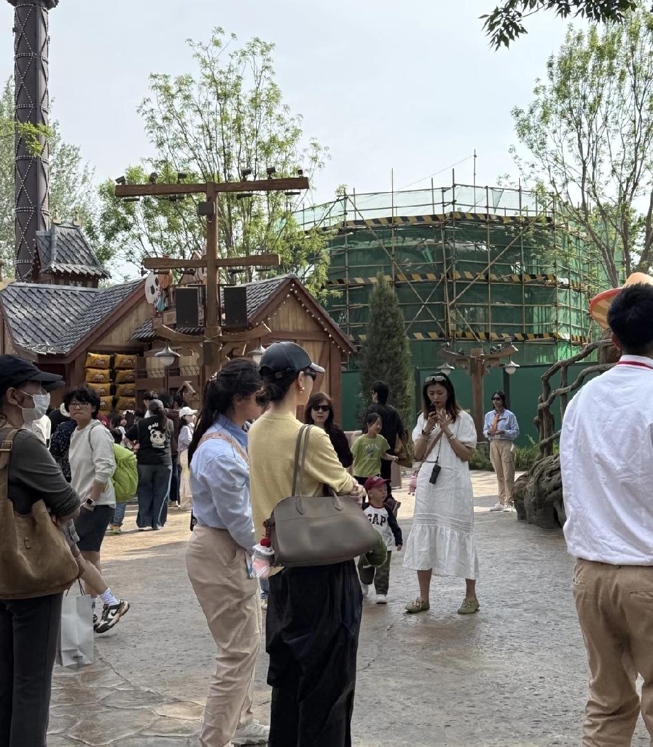 戚薇带着孩子现身泡泡玛特公园，她和孩子在园里走着，时不时抬手跟认出她的游客打招呼