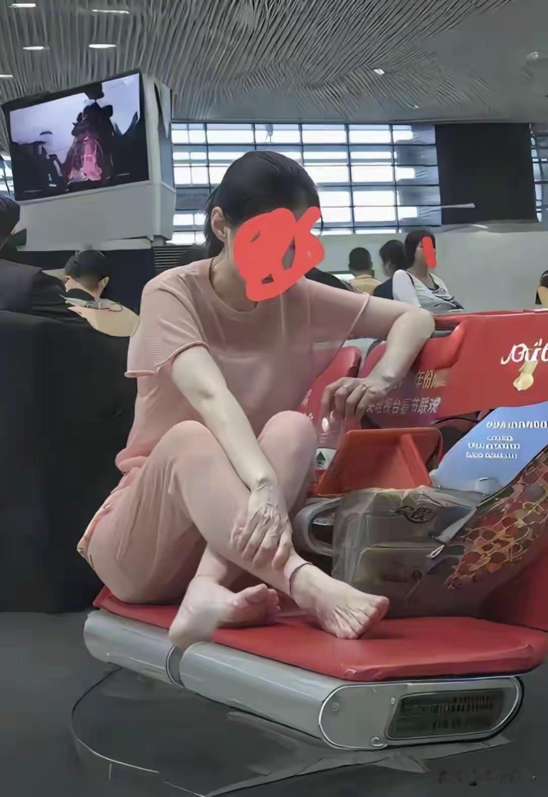 这个美女是把候车大厅当自己家了，惬意的光着脚斜坐在候车大厅座椅上，虽然人长得很漂