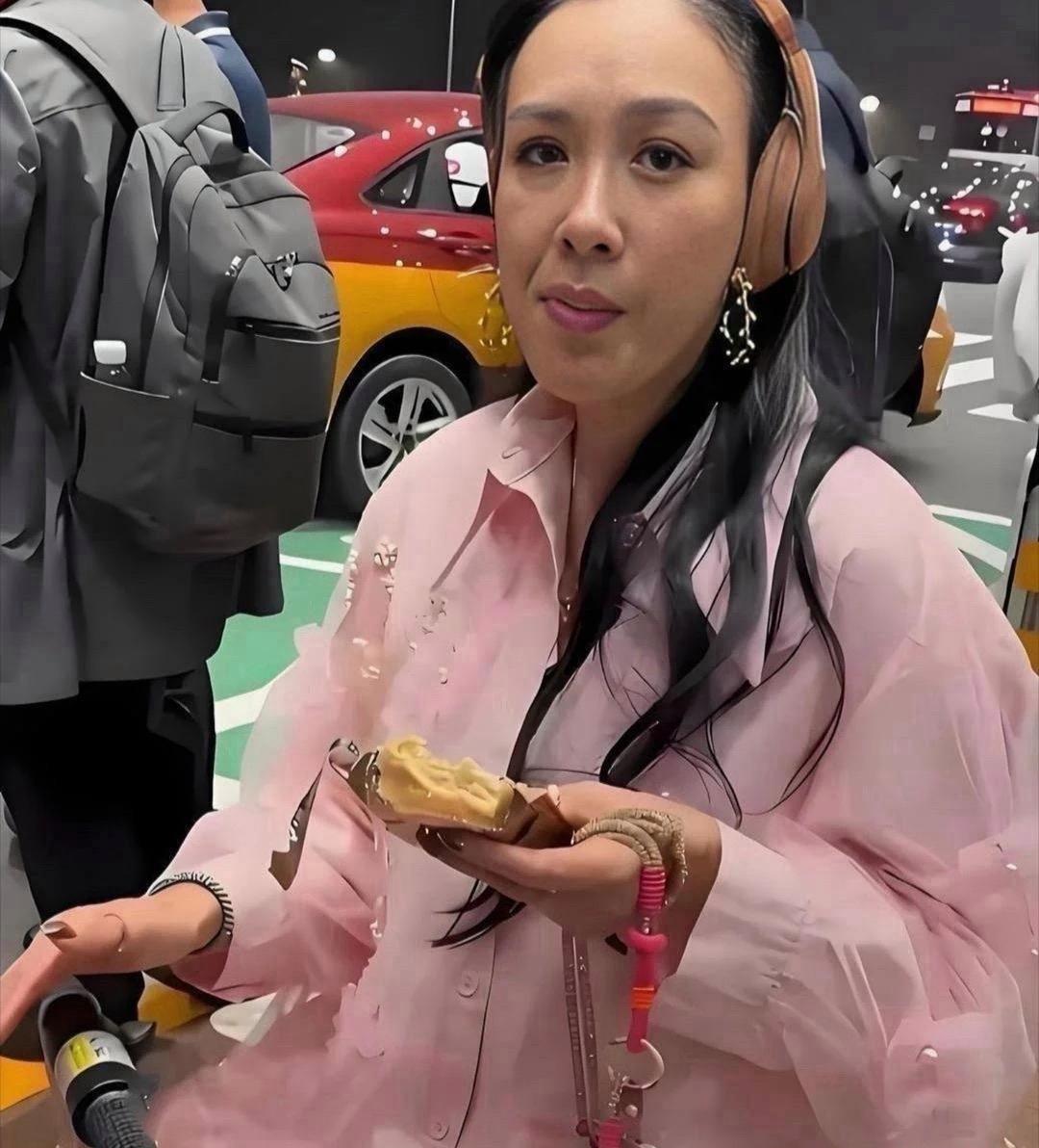没有滤镜下的钟丽缇，容貌太真实了。她身着嫩粉色衬衫，衣身点缀珍珠碎钻，搭配软质耳