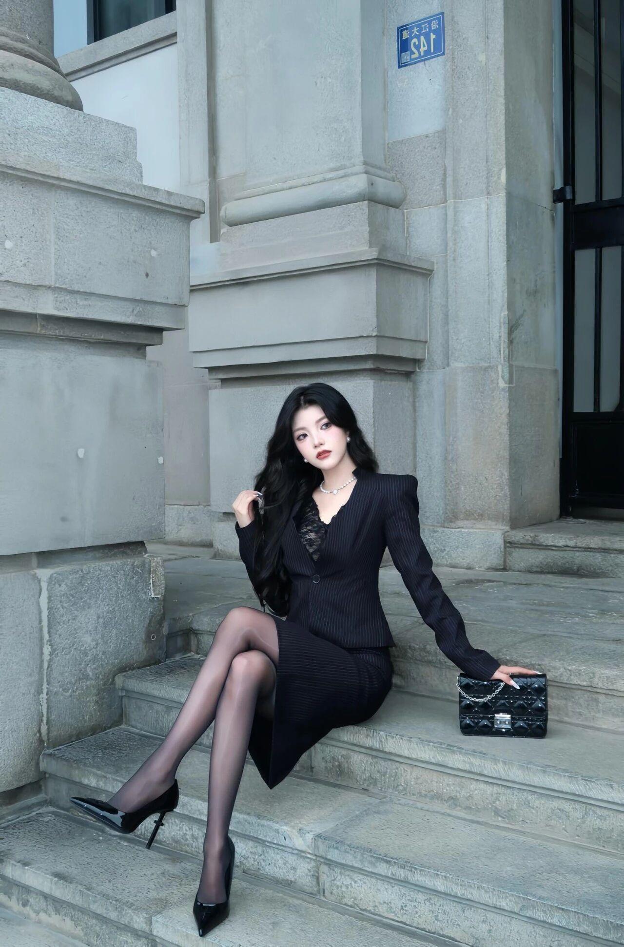 “黑色西装套裙+光泽袜+小高跟”，精致干练，优雅自信这套黑色套装的上衣是修身款