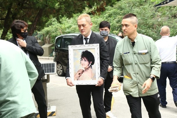 施明葬礼施明出殡据港媒，香港演员施明葬礼于23日举行，她的长子捧着遗照，幼子紧