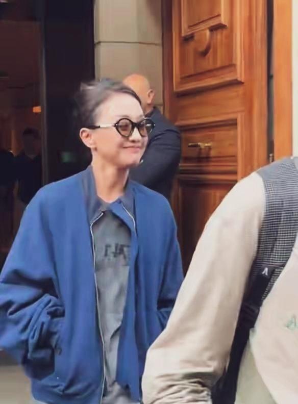 周迅巴黎出行接地气蓝色宽松夹克衫内搭灰色体恤，头发稀疏随意盘起，黑框眼镜一戴，有