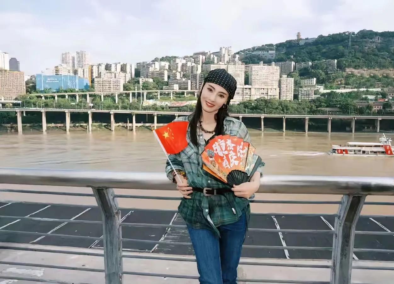 张柏芝表白祖国，好甜！张柏芝在江边，手举着小国旗和写有“重庆你好”的扇子，