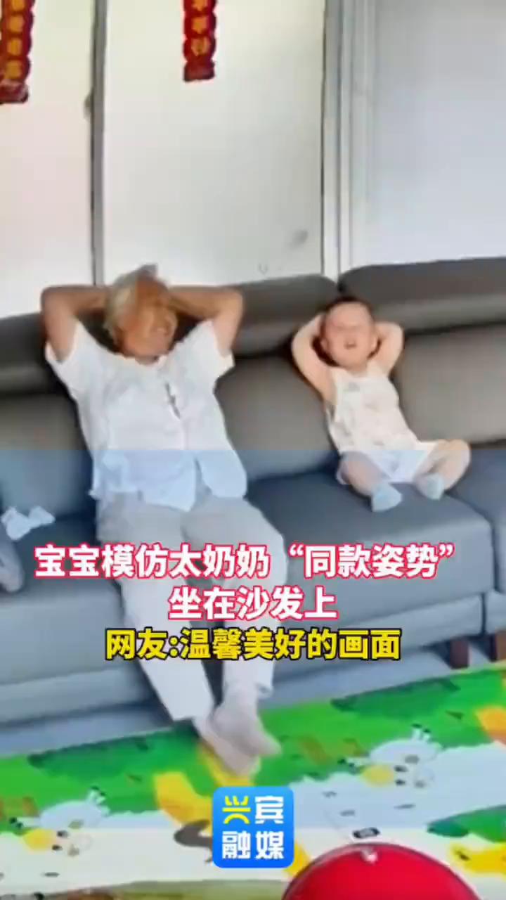 宝宝模仿太奶奶"同款姿势"坐在沙发上。兴宾融媒。网友：温馨美好的画面。7月