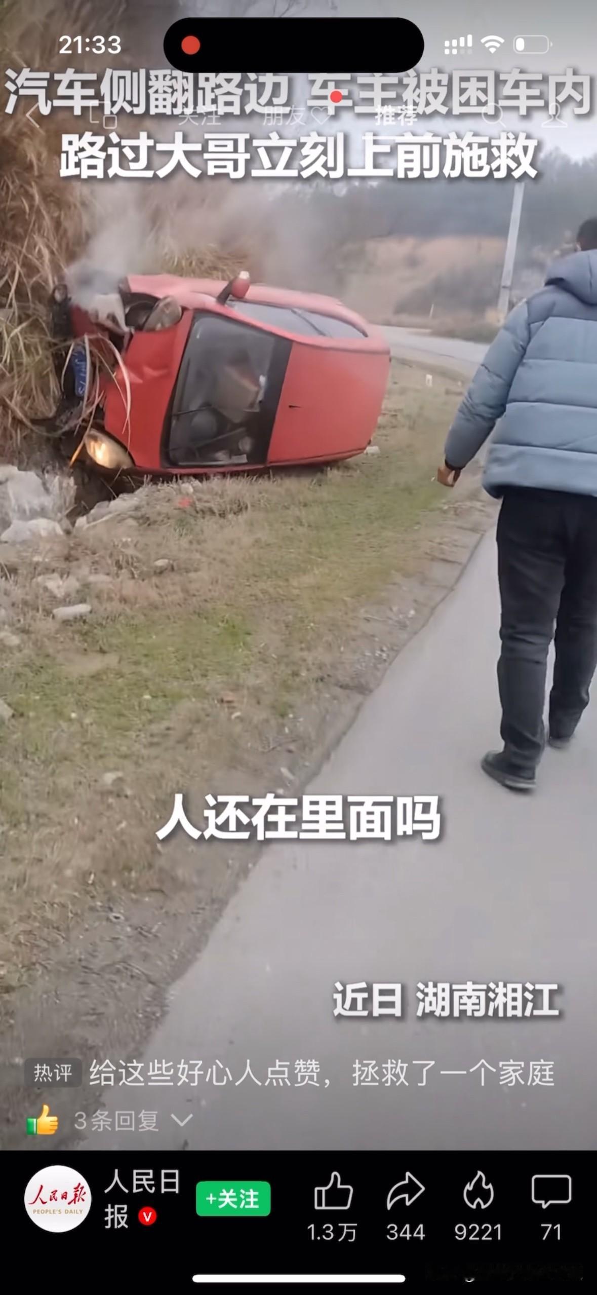 湖南湘江，一辆汽车侧翻在山路边，车子底下正在冒着烟，驾驶员被挤压在车里面动弹不得