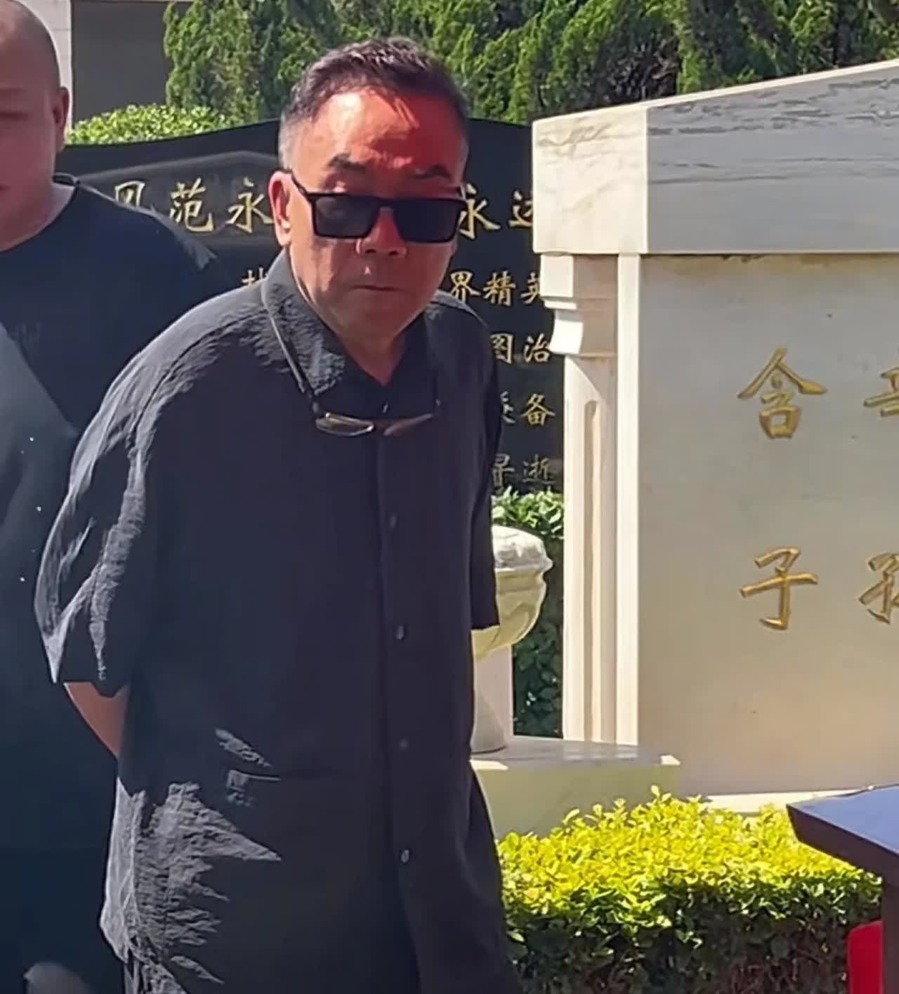 杨少华入土，几个儿子表情各异。小儿子杨议双手背后，表情凝重。大儿子杨威趴