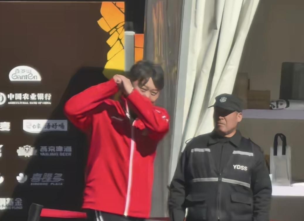 孙逊被球迷喊话“照顾好王楚钦”，真实场景其实是在马路边，他低头微笑、双手合十，而不是网传的拿快递边跑
