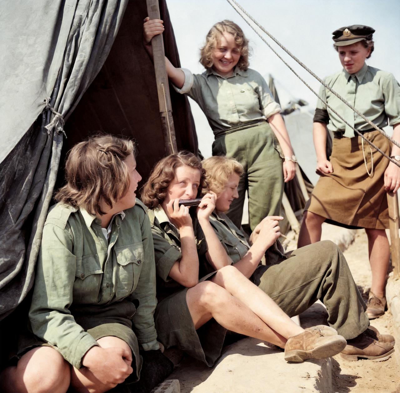 这是1945年盟军集中营中的德国女兵的生活状态。其中有的女兵吹口琴，有的女兵缝衣