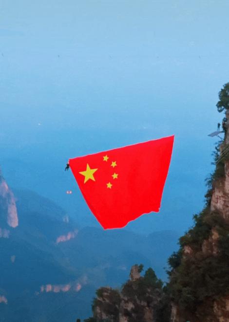 河南云台山，每到国庆前夕，悬崖峭壁上都会悬挂起一面巨幅五星红旗。不少游客登临山间