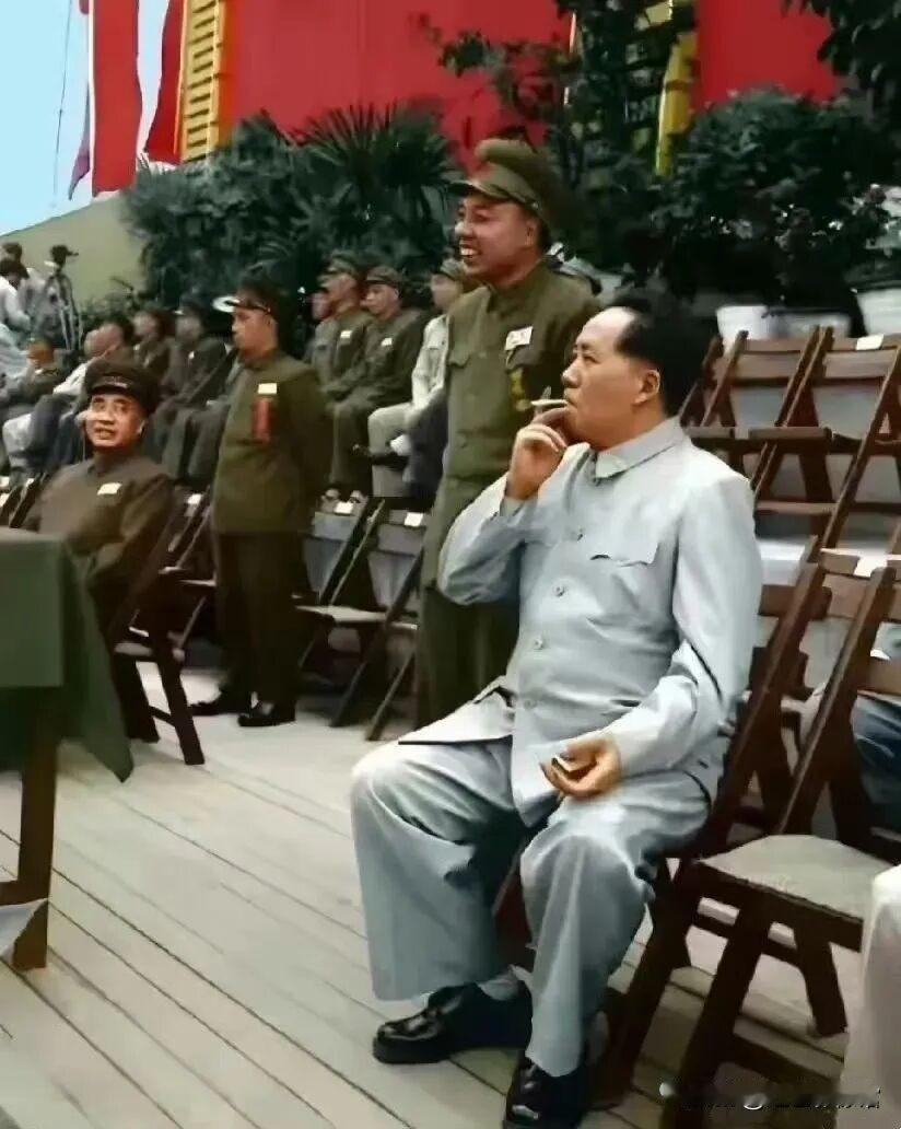 这张经典彩色老照片拍摄于1952年全军运动会现场，毛主席身旁开怀大笑、神情格外爽