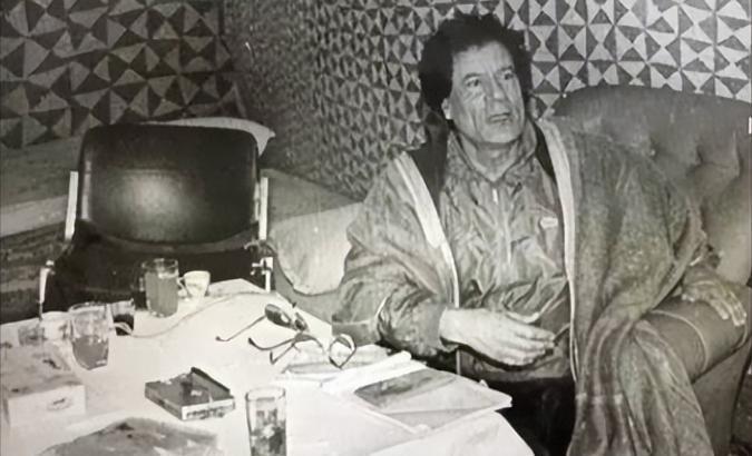 1992年，中国记者唐师曾与卡扎菲合影并请他签名，卡扎菲签完名递给唐，并拍拍他的