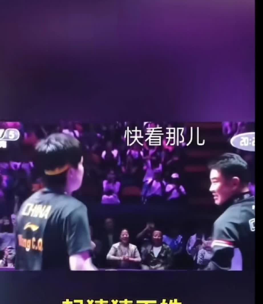 王皓手指着观众席的一个方向让王楚钦看，王楚钦看到了也用手指了指，猜猜王皓指的是谁