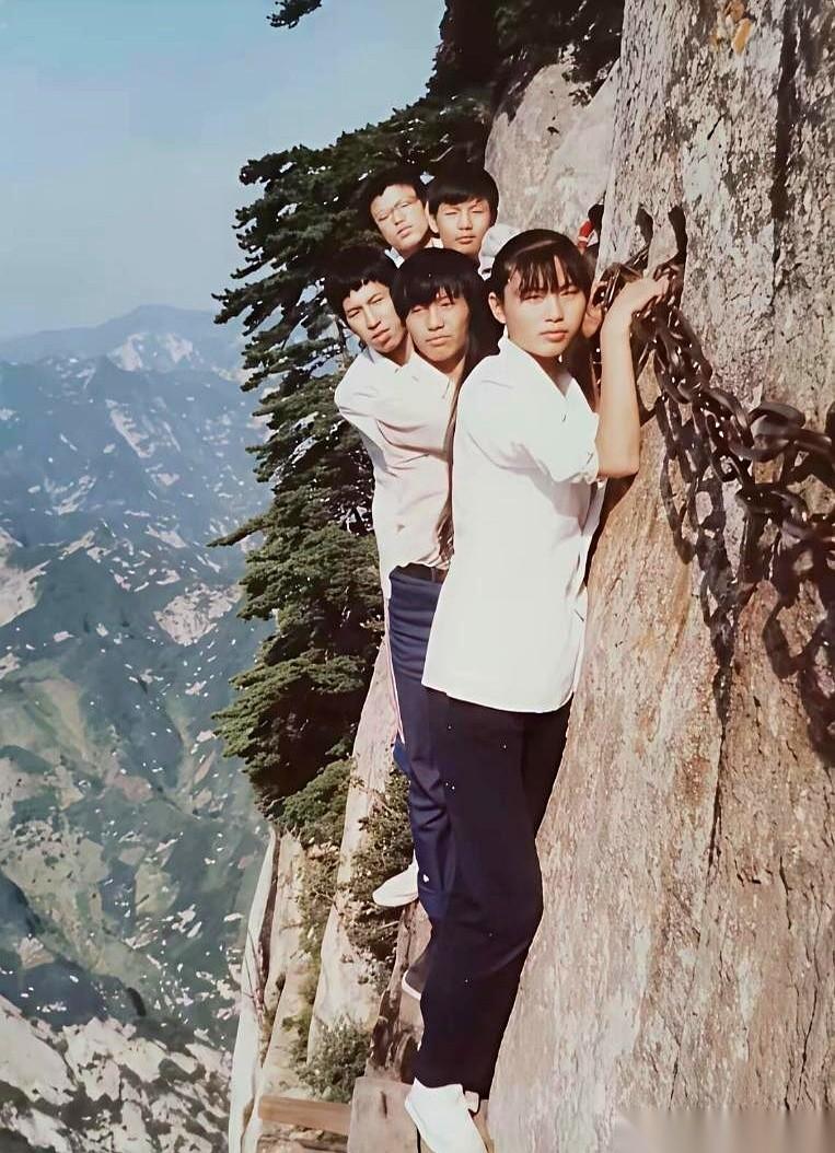 1987年，华山，一张黑白老照片。几个少年挤在悬崖边上，咧着嘴笑。他们身后没有