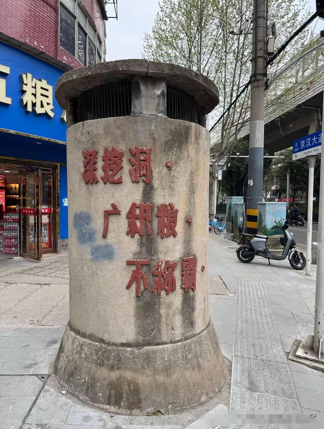 武汉街头这根水泥柱子，我路过一百次都没留意过。直到有人指着上面那行快掉光的红