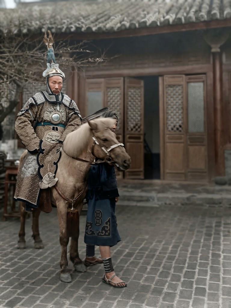 照片中，居中稳坐于马上的老者，正是清末广西提督、抗法名将苏元春。他头戴饰有翎羽的