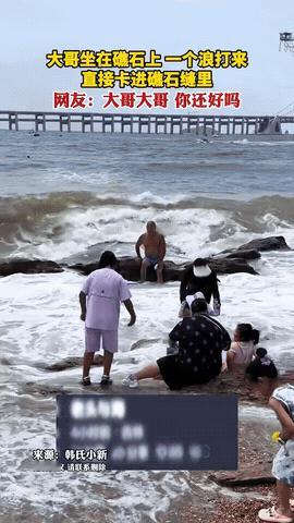 哭笑不得！辽宁大连，大爷仗着自己水性好坐在海边礁石上，结果一个大浪拍来，大爷直接