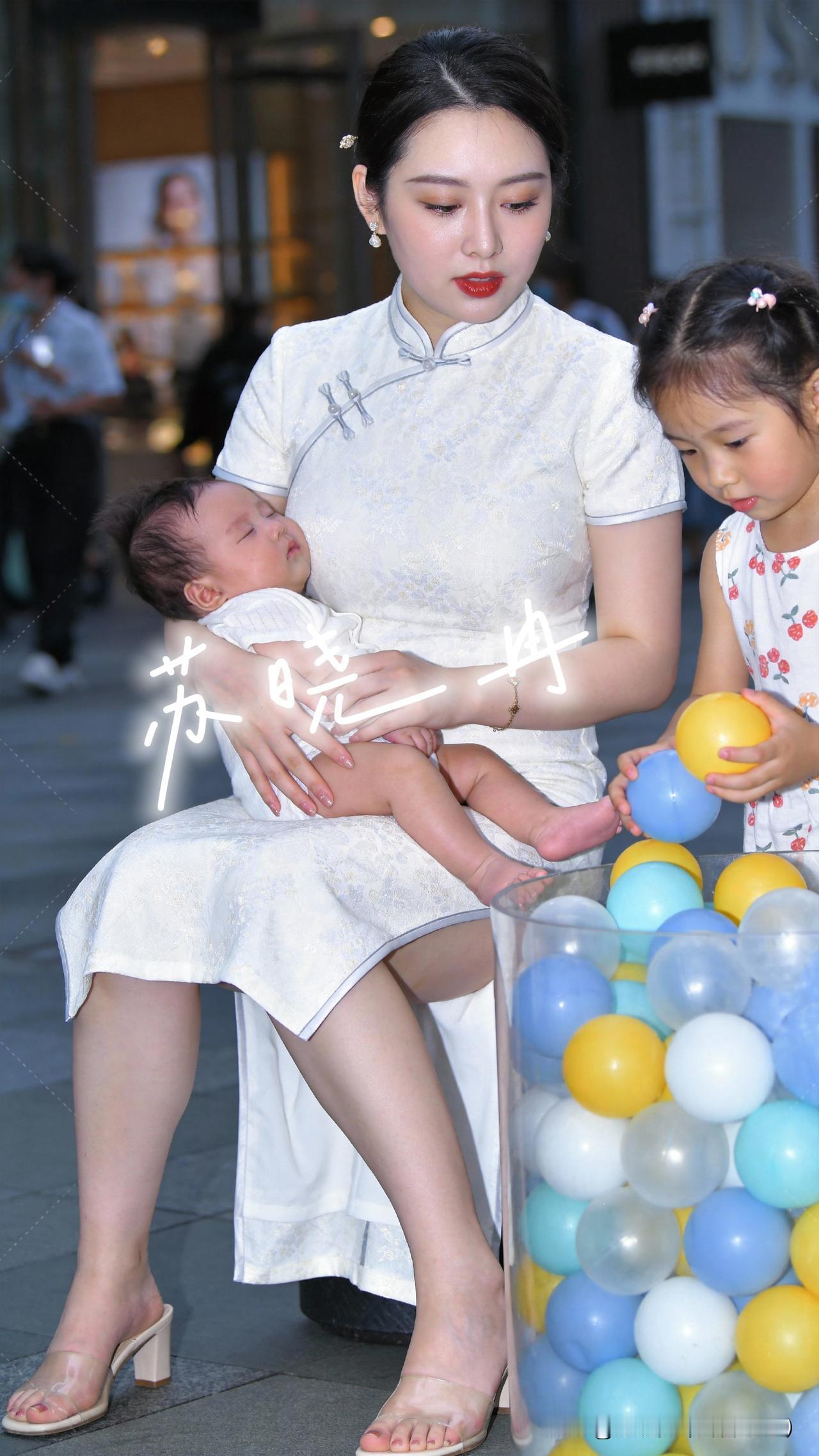 弟弟安睡妈妈怀，姐姐在波波球池自顾自玩，画面好治愈出门偶遇超真实的二胎带娃画面