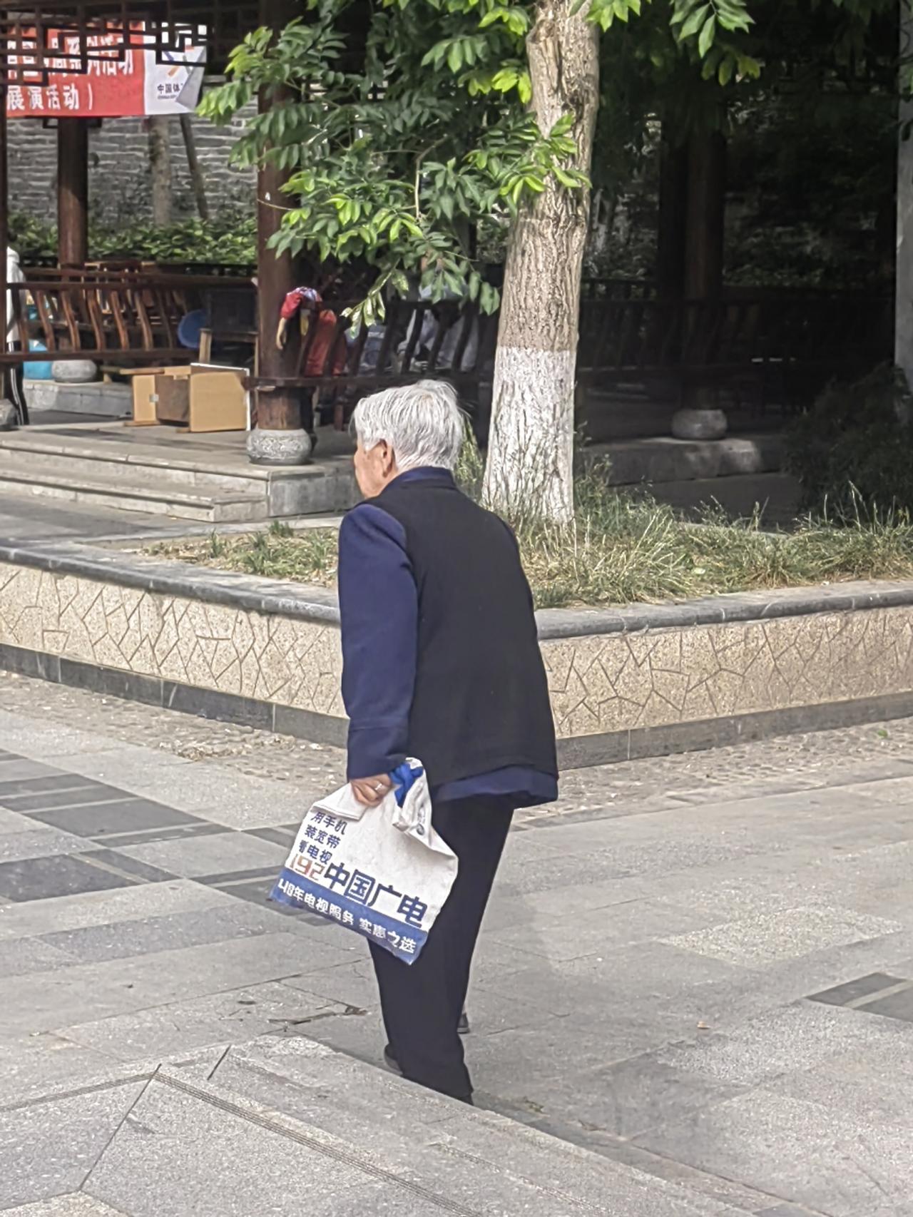 图片中弯腰驼背走路的老人，是我的舅母，今年八十四岁，她生了五个儿子，个个都是人中