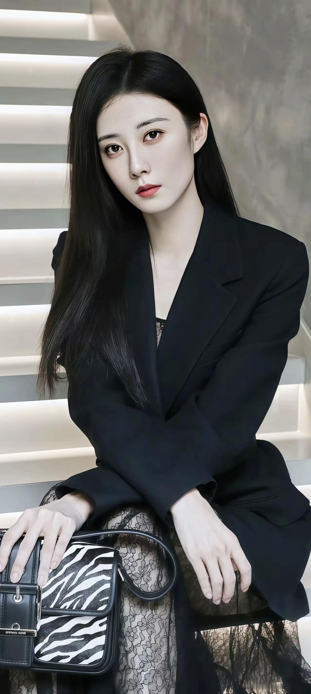 一个穿黑色西装的美女坐在楼梯上。职业西装女神范气质西装女神