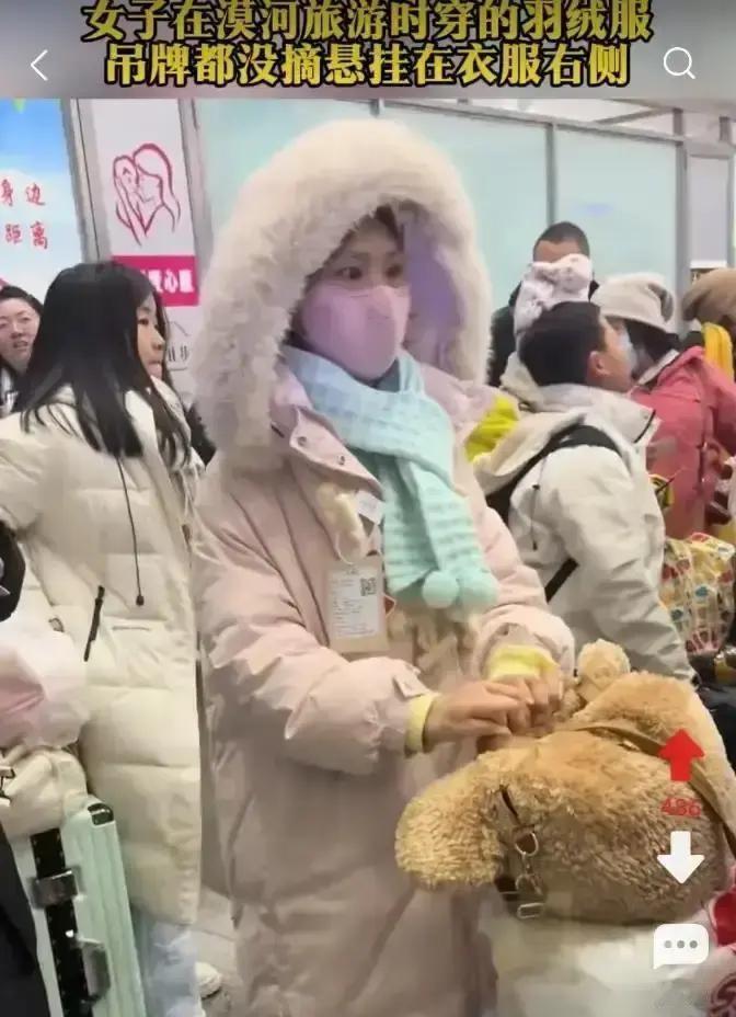 漠河景区排队口，一个粉羽绒服女生吊牌晃得显眼，被拍视频发上网。48小时冲上热搜