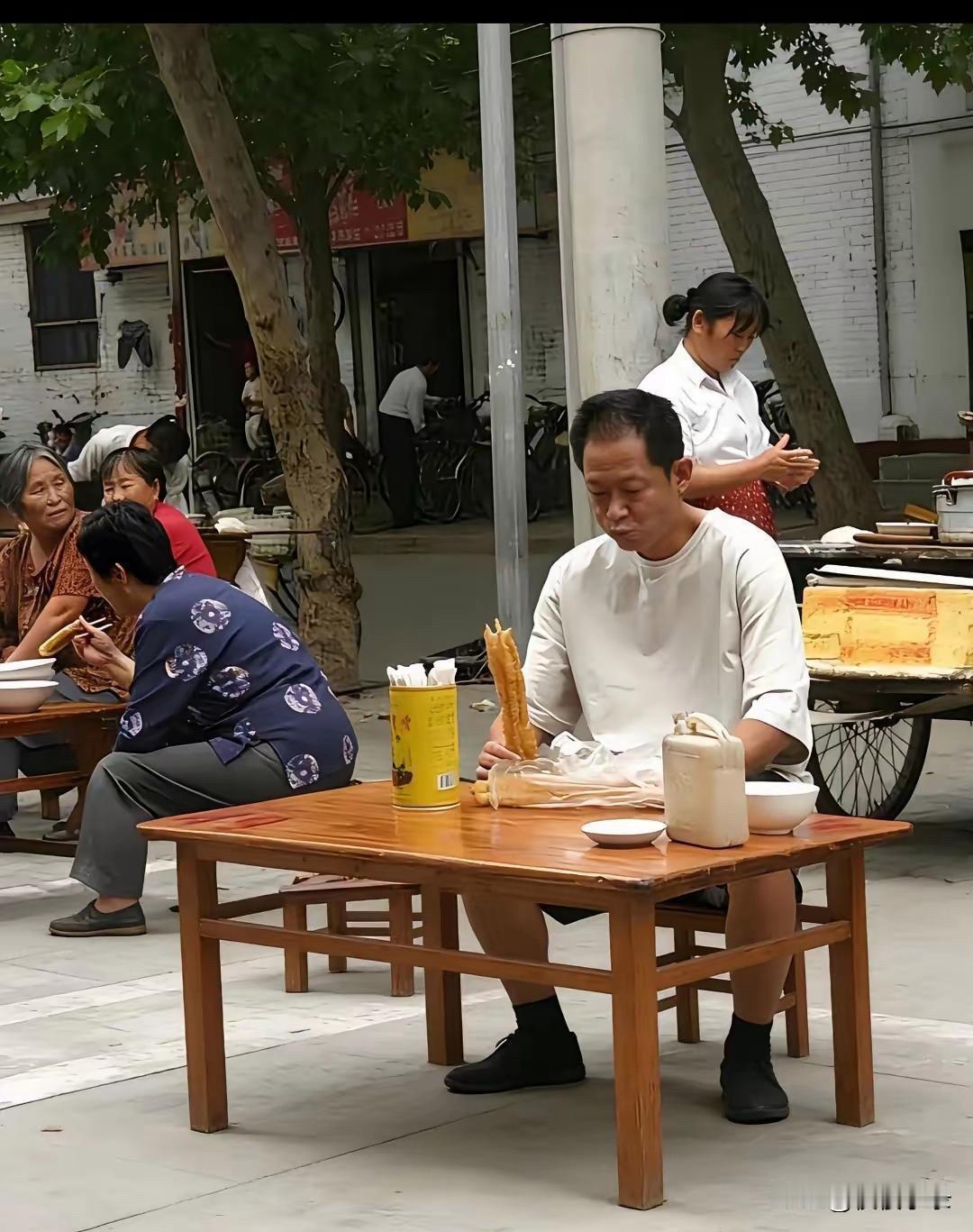 王志文又被拍到了。一个人坐街边吃早餐，一根油条吃得津津有味！[灵光一