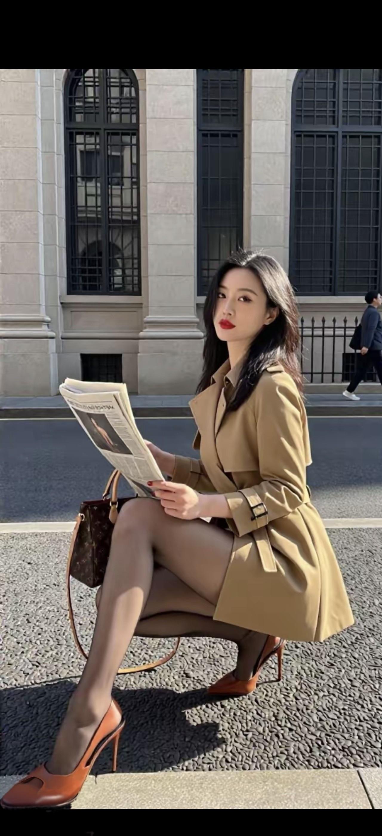 一个美女在街头看报纸。