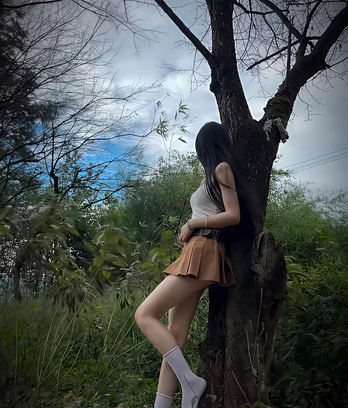 少女倚树沉思，绿意盎然中，静享自然之美。