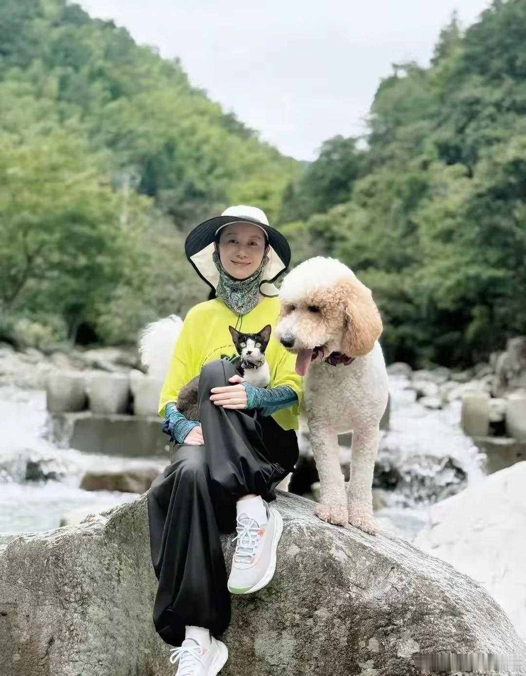 47岁的倪虹洁与萌宠相伴，漫步于美景之中。她身着一袭白裙，随风轻漾，仿若仙子下凡