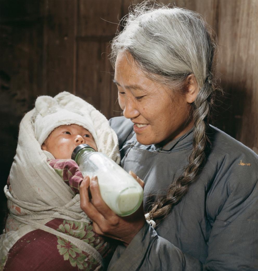1958年，被称为四川“白毛女”的罗昌秀，抱着自己孩子温柔喂奶，照片中她头发开始